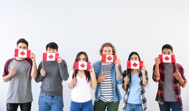 Des étudiants tiennent des drapeaux du Canada.